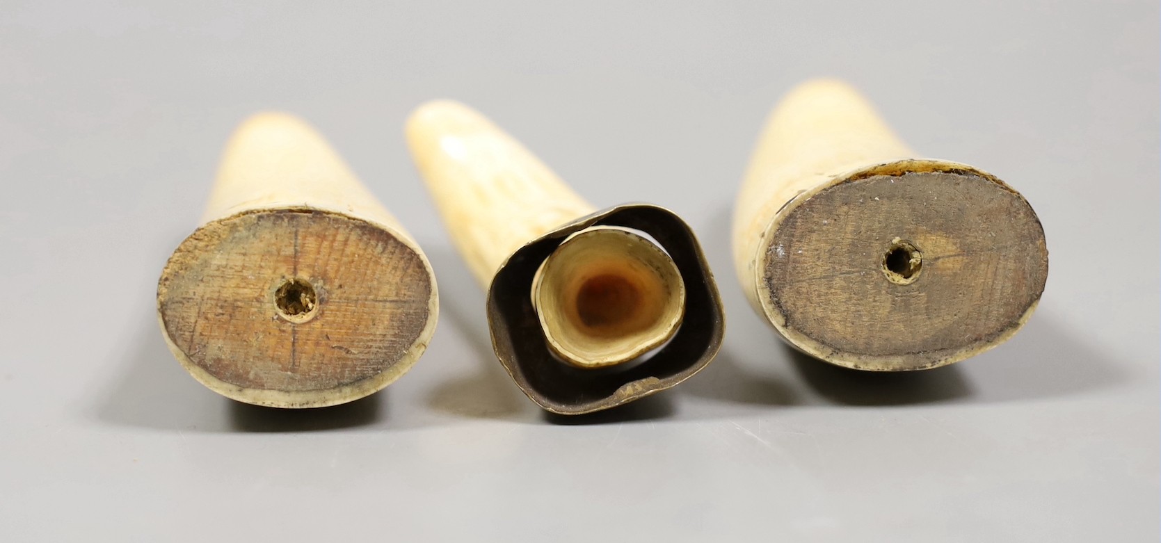 Three 19th century scrimshaw sperm whale teeth, tallest 10cm